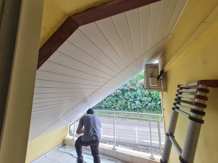 Le faux plafond PVC blanc terminé sous l'escalier extérieur, jusqu'au climatiseur